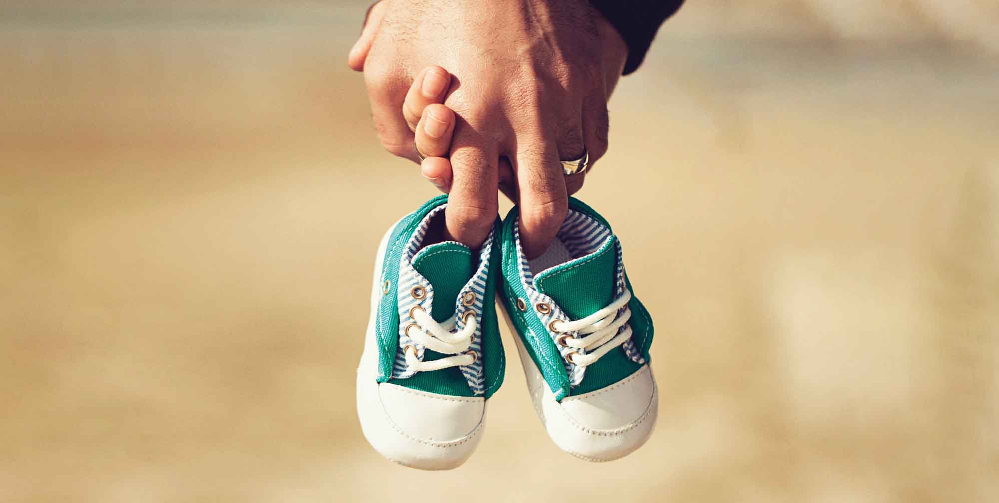 hands holding baby shoes
